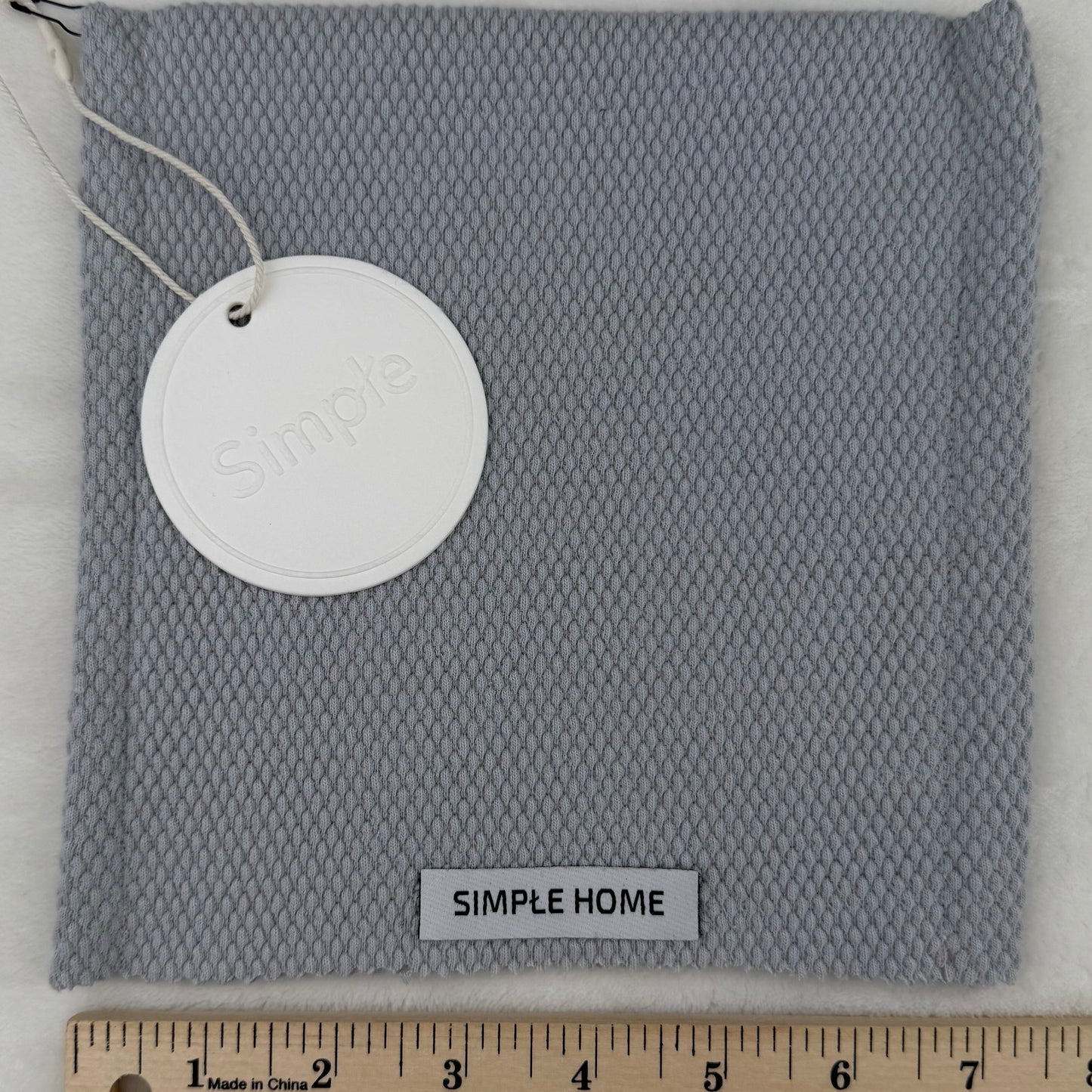 Gray fabric with a tag and ruler on a white background