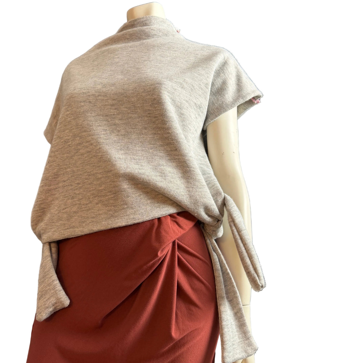 A light heather gray knit wrap or shawl draped over a mannequin torso, paired with a rust red skirt, against a plain white background.
