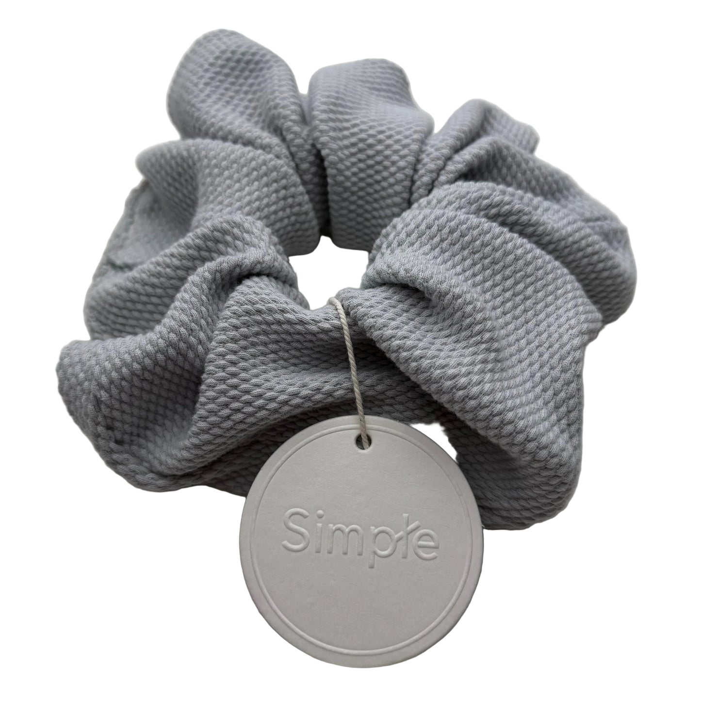 Gray scrunchie with a 'Simple' tag on a light gray background