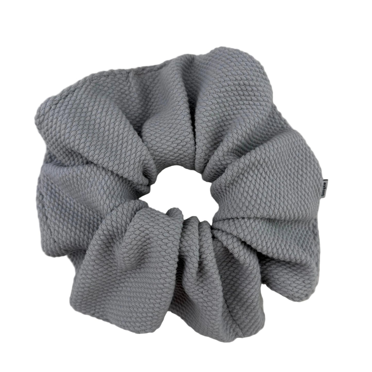 Gray textured scrunchie on a light gray background
