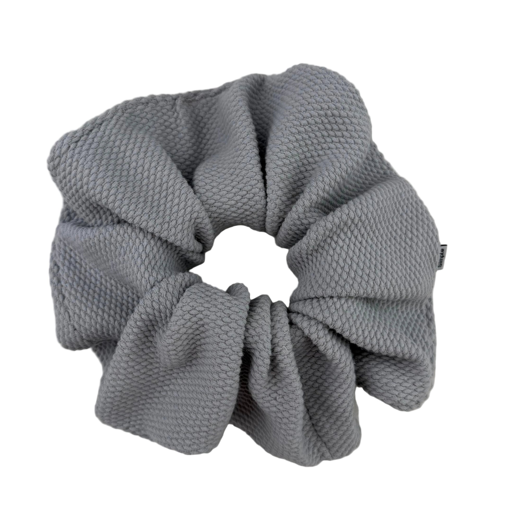 Gray textured scrunchie on a light gray background