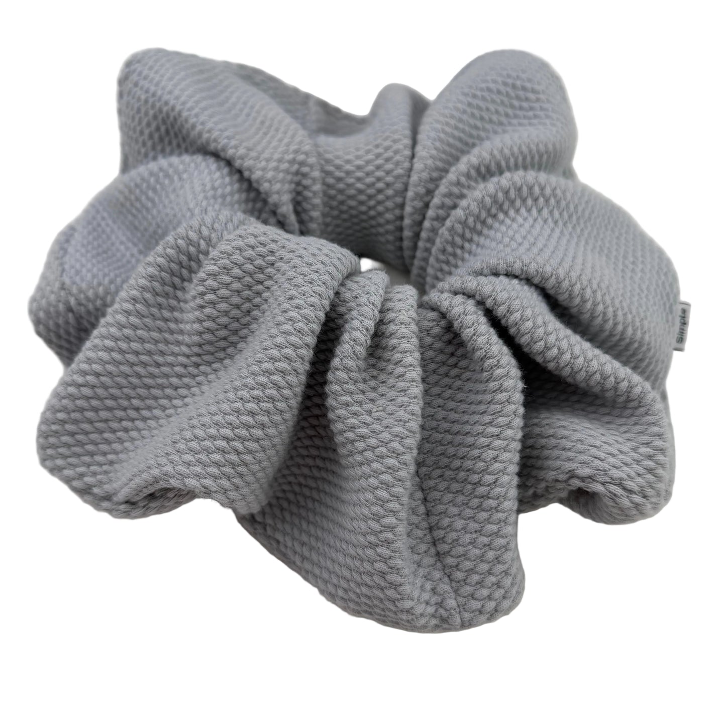 Gray textured scrunchie on a light gray background