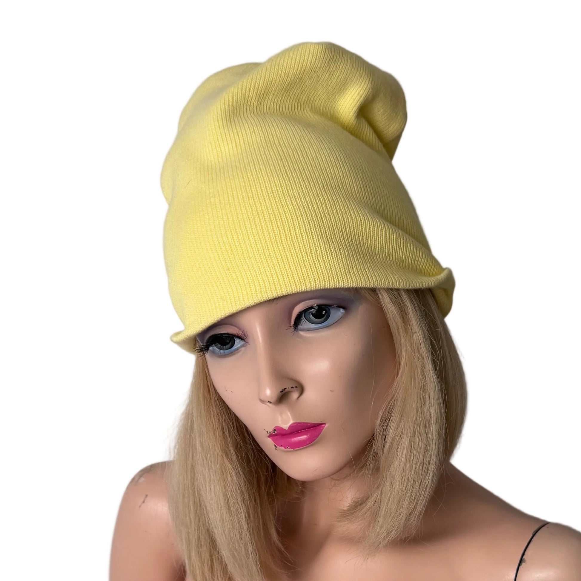 Mannequin wearing a yellow beanie and pink top against a plain background