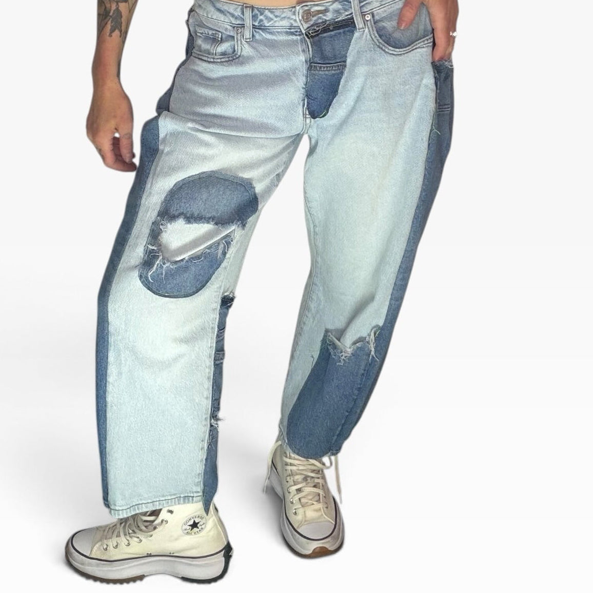 High-rise patchwork denim jeans in light and medium blue washes with distressed details and a relaxed fit.