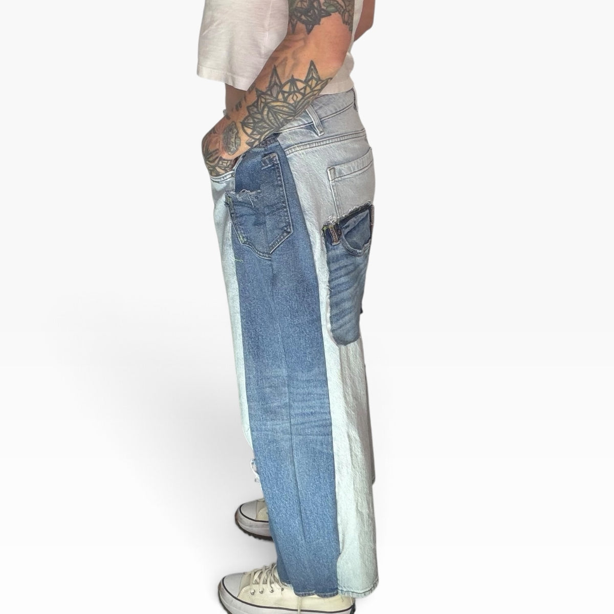 Side view of high-rise patchwork denim jeans featuring light and medium blue washes with distressed raw-edge details.