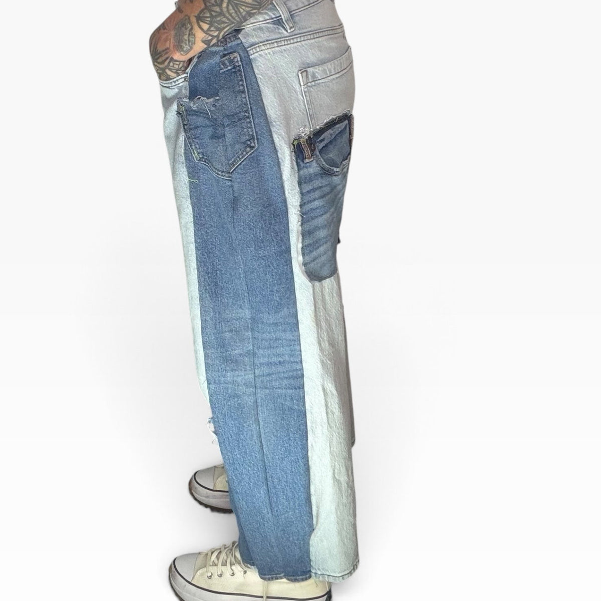High-rise patchwork denim jeans featuring mixed blue washes, distressed details, and a relaxed fit, side view.