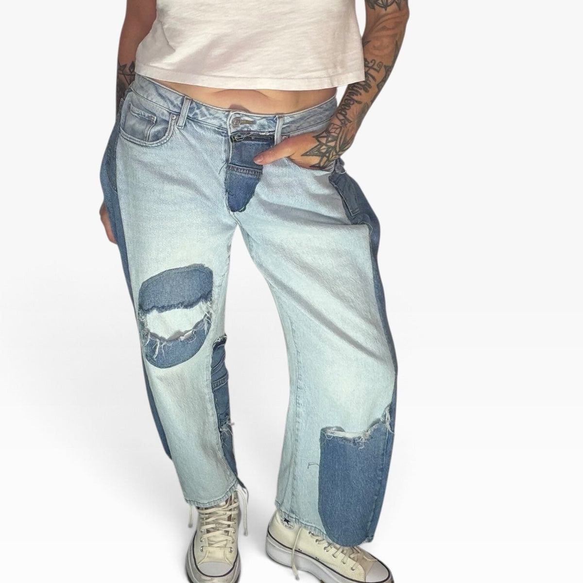 High-rise patchwork denim jeans in light and dark blue washes with distressed details and a relaxed fit.